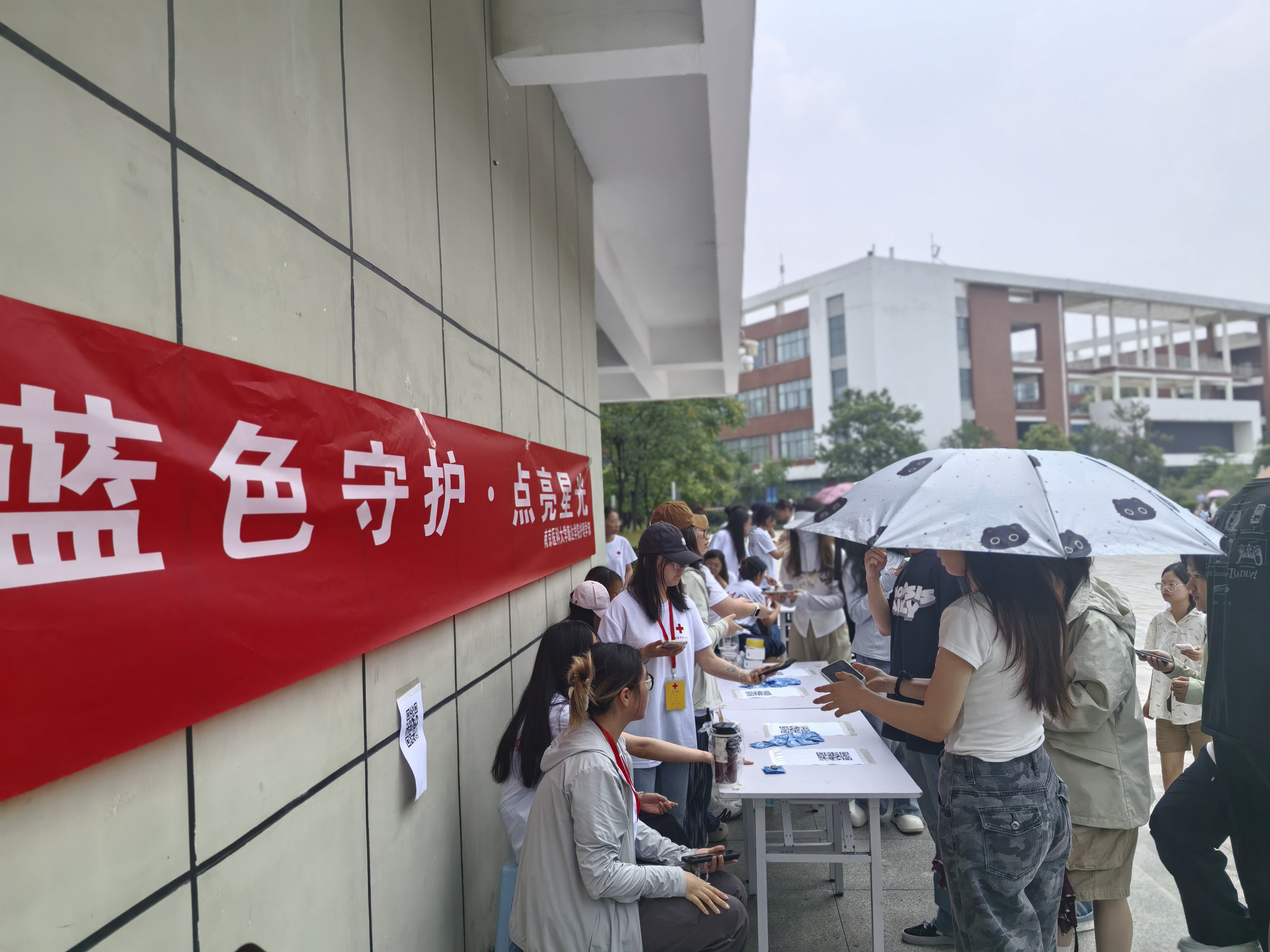树人广场活动现场,志愿者引导在校学生扫码填写自闭症认知电子问卷.jpg